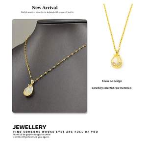 Detail of tulip pendant in 18K gold finish with cat-eye stone and zircon accents