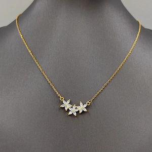 Exquisite gold flower necklace with three marquise cut zircon pendants on a gray bust