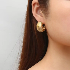 Boucles d'oreilles en acier inoxydable doré en forme de U portées par un mannequin