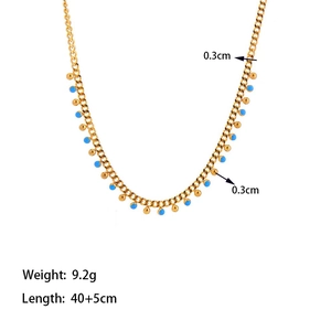 Gold beaded necklace with blue enamel accents and tassels on a clean white background