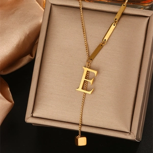 Gedetailleerd beeld van de gouden E-hanger ketting met lange schakels en kubusbedeltje