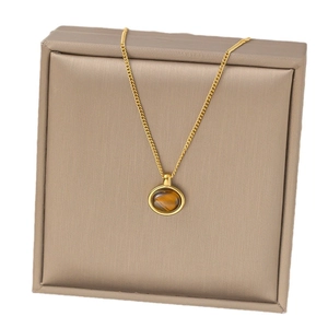Collier élégant en pierre œil de tigre avec chaîne en titane doré sur un coffret cadeau