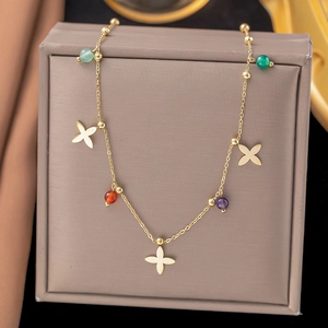 Goldene Kreuz-Blüten-Halskette mit bunten Perlen auf einer eleganten Schmuckschachtel
