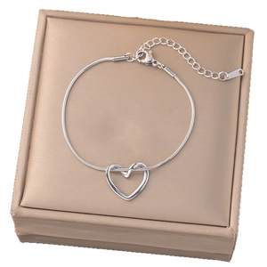 Eleganter Armband mit hohlem Herzanhänger und Schlangenkette auf Schmuckschatulle