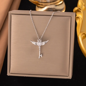 Detailed macro shot of zircon-encrusted silver crown key pendant necklace on a jewelry box