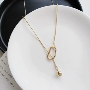 Elegant gold-tone long sweater necklace with geometric ring and polished bead pendant