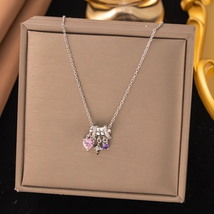 Silver necklace with pink heart-shaped stone and purple crystal pendant on dark display