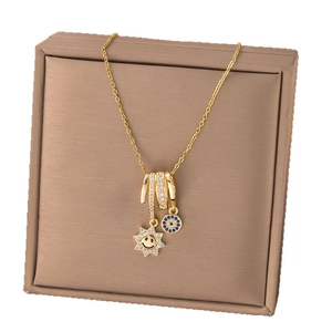 Golden necklace with sparkling sun and evil eye pendants on a jewelry display box