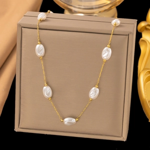 Detail of baroque pearl necklace with gold chain displayed on a luxury jewelry box