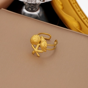 Detailansicht goldener Edelstahlring mit Seestern- und Muschelmotiven, offene Form