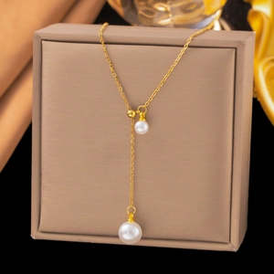 Collier en Y réglable avec chaîne dorée et deux pendentifs perles sur fond de soie