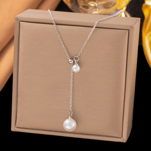 Élégant collier en Y argenté avec pendentif perle et pompon long sur boîte à bijoux