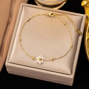 Dettaglio della collana in acciaio inossidabile dorato con fiore di perle e chiusura