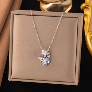 Détail du collier argenté avec pendentif en émail bleu et blanc sur boîte à bijoux