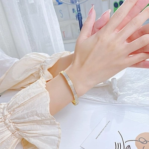 Elegant gold titanium steel bracelet with sparkling micro-pave zirconia crystals on wrist