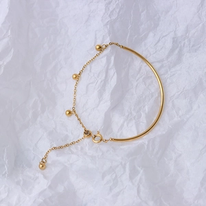 Minimalist gold titanium steel splice bracelet with polished arc bar and bead charms