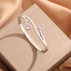 Eleganter S-förmiger Edelstahl-Armreif mit rosa Zirkonia-Steinen auf Champagner-Seide