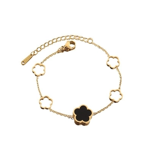 Detail of gold titanium steel bracelet with five-petal flower motifs and black inlay