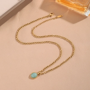 Detalle del collar chapado en oro con cristal ovalado azul claro y cierre de mosquetón