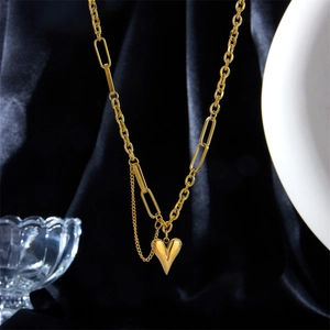Dettaglio ravvicinato di una collana con ciondolo a cuore dorato su velluto nero
