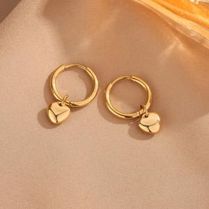 Polished gold heart drop hoop earrings made of medical grade titanium steel on fabric