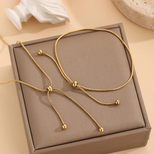 Detail van verstelbare 18K gouden slangenketting set met schuifkralen op een doos