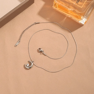 Detailaufnahme einer silbernen Mondkette mit Zirkon, elegant in einem Geschenkbox-Kontext