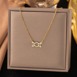 Collier déesse triple lune plaqué or présenté dans un écrin de bijoux de luxe
