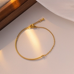 Elegantes Armband aus goldenem Titanstahl mit asymmetrischer Kette und Zirkonia-Detail