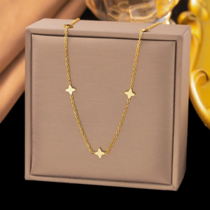 Detailed view of elegant gold necklace with star charms on a luxury jewelry gift box
