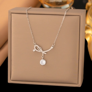 Collana con ciondolo a fiocco e zircone scintillante su una scatola di gioielli