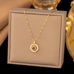 Detailed view of gold moon necklace with ROMAN numeral rings and projection stone