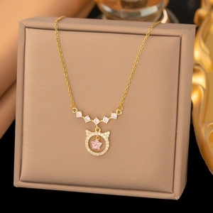 Nahaufnahme einer Goldhalskette mit rosa Stern-Edelstein und Zirkon-Katzenanhänger