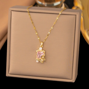 Detailansicht der goldenen Blumenkette mit rosa Kristall und weißer Perle auf Display
