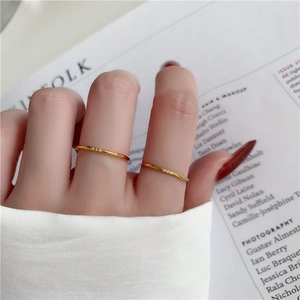 Minimalistische goldene Titanstahlringe mit drei Zirkonia-Steinen an der Hand