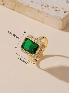 Détail de la bague émeraude vintage avec pierre verte rectangulaire et halo de zircons