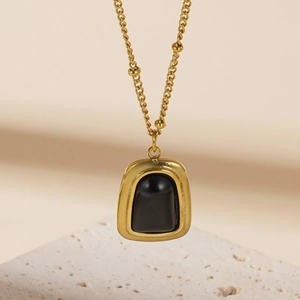 Collana dorata vintage con ciondolo in pietra nera e dettagli di catena con perline