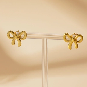 Elegant gold bow-shaped titanium steel stud earrings displayed on a minimalist stand