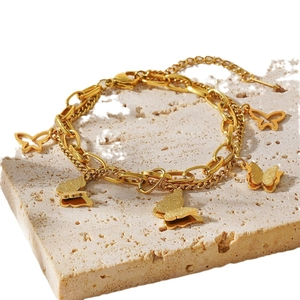 Elegant 18k gold double-layer butterfly bracelet with lobster clasp on travertine stone