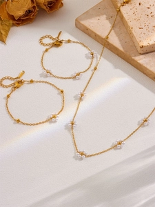 Detailed view of handmade 18k gold beads chain necklace and white pearl flower jewelry