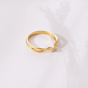 Minimalist gold knot ring with twisted rope design on an elegant textured background