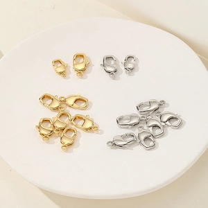 Detail of gold and silver lobster clasps in two sizes on a white display stand