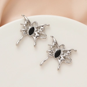 Macro shot of silver metal butterfly pendant with black marquise gemstone detail