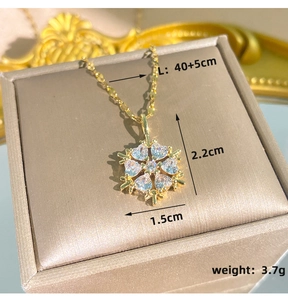 Detailansicht der goldenen Schneeflocken-Halskette mit genauen Maßen von 2,2 cm und 1,5 cm