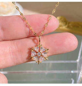 Makroaufnahme eines Schneeflocken-Anhängers mit Zirkonia-Steinen in einer Gold-Fassung
