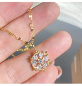 Details der goldenen Schneeflocken-Halskette mit Herz-Zirkonia-Steinen und flacher Kette