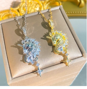 Dettaglio di ciondoli a forma di unicorno con zirconi e nappine a forma di stella