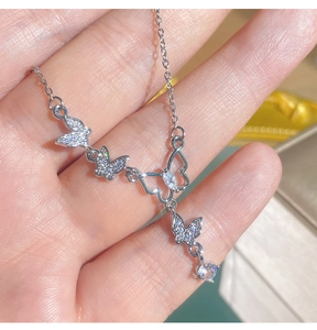 Détail du collier papillon argenté serti de zircons avec une chaîne fine et élégante