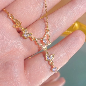 Collier exquis en titane doré avec pendentifs papillons et pierres scintillantes