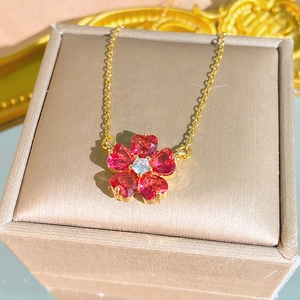 Elegante collana in titanio dorato con ciondolo a fiore di cuore in zircone rosso su astuccio